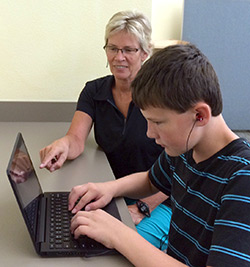 Mrs. Holzman helps Trei on the computer