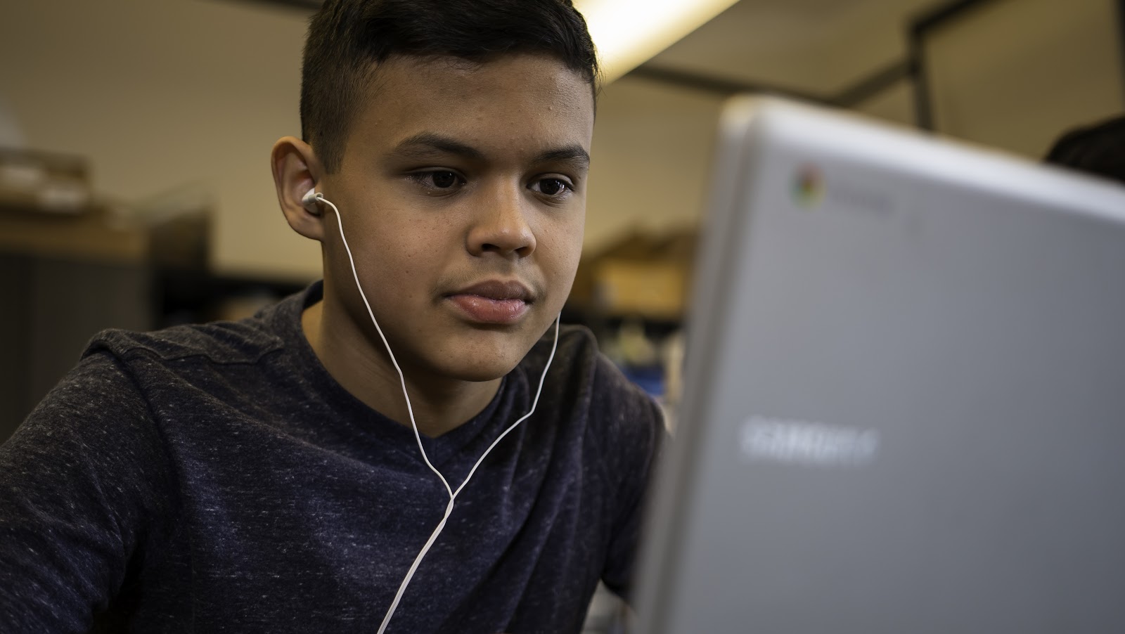 Student works at computer with headphones