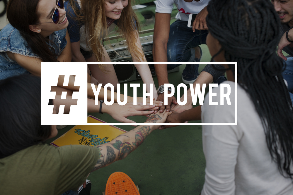 Hashtag Youth Power written over a group of happy teens forming a hand pile