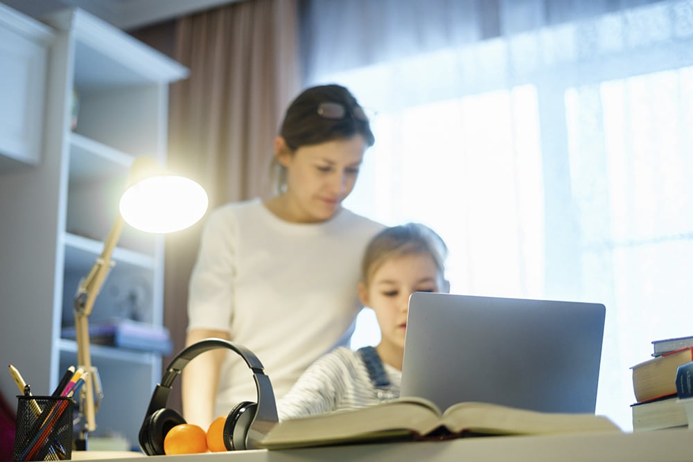 Mother and daughter working on school work at home