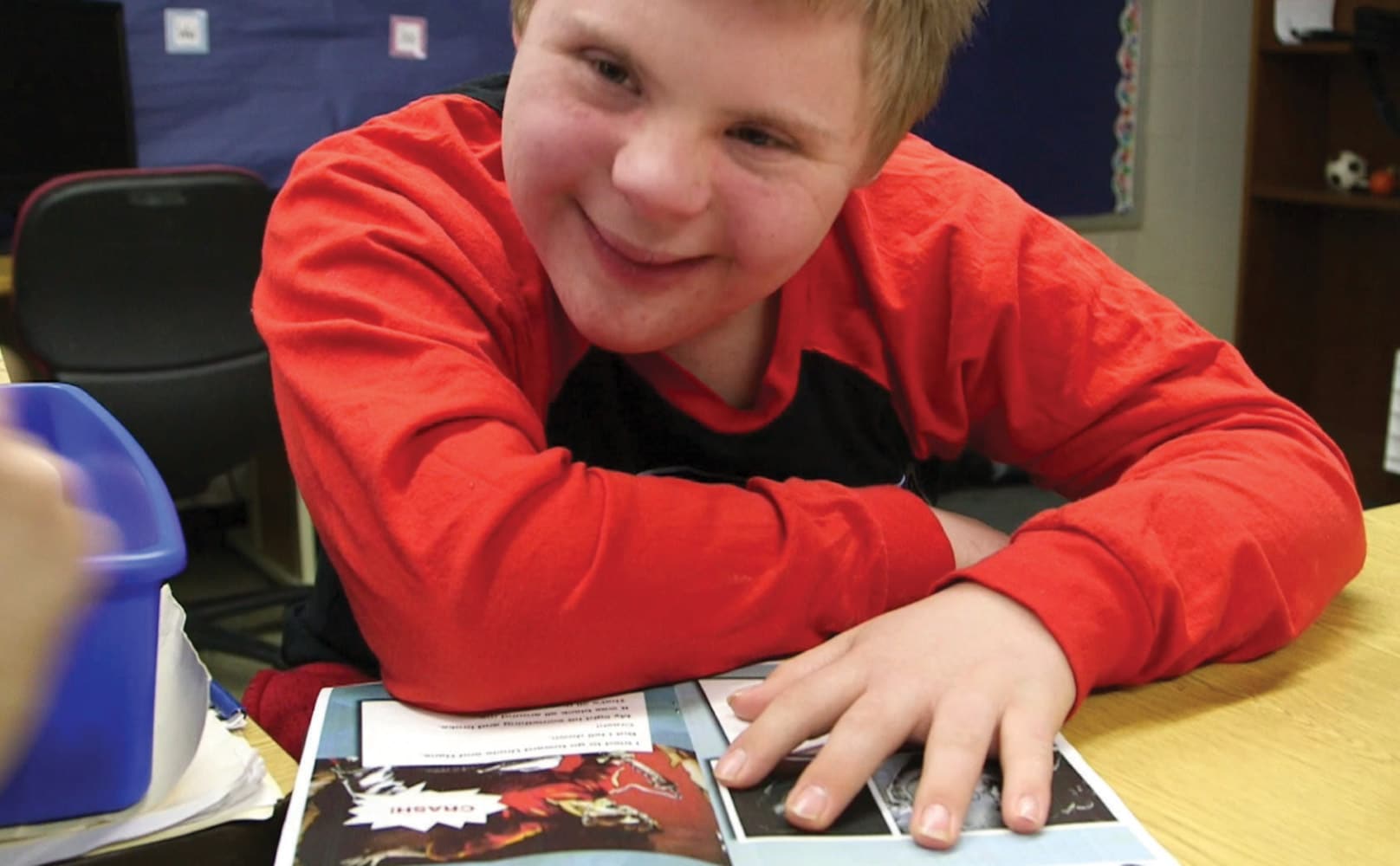 Readtopia student in red shirts reading a graphic novel