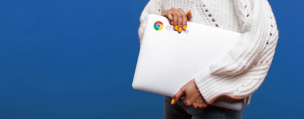 Woman in sweater holding a chromebook