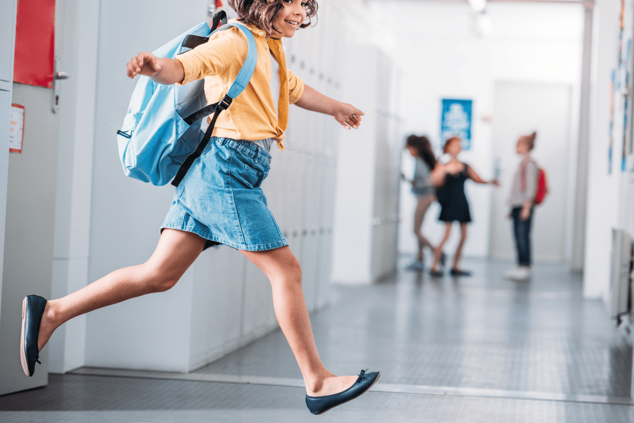 Schoolgirl running through school corridor
